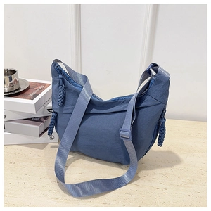 Dettaglio della borsa a mezzaluna in nylon blu scuro con tessuto e tirazip intrecciato