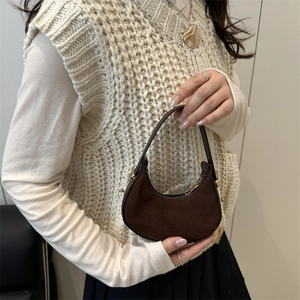 Deep brown faux suede hobo bag with gold zipper and leather handle shown in use