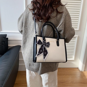 Minimalist black and white lizard pattern handbag with silk scarf on model