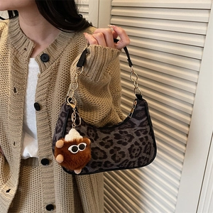 Chic leopard print crescent shoulder bag with gold chain strap and plush charm