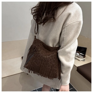 Detail of a large brown leopard print tote bag with long fringe and faux suede texture