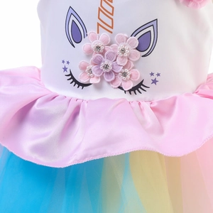 Détail de robe licorne avec fleurs 3D, perles et tissu en maille de tulle arc-en-ciel