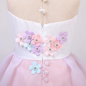 Detail eines weißen Einhorn-Prinzessinnenkleids mit Blumenstickerei und rosa Tüll