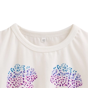 Detail of white cotton knit girls' top with round neckline and colorful leopard prints