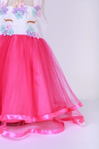 Detailed close-up of unicorn dress showing 3D floral appliques and layered pink tulle skirt