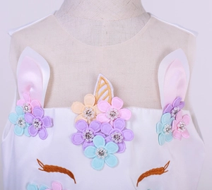 Detail of unicorn princess dress with floral embroidery, pearls and golden horn