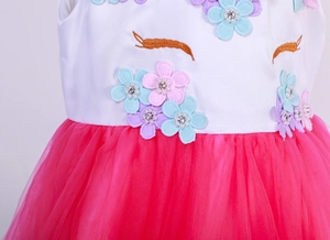 Detail of unicorn dress with floral appliques, eyelash embroidery and pink tulle
