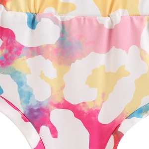 Close-up of colorful tie-dye cow print fabric on kids knit set with ribbed texture