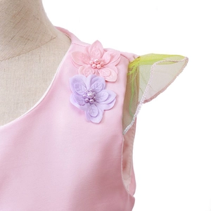 Nahaufnahme eines Mädchenkleides mit handgefertigten 3D-Blumenapplikationen und Perlen