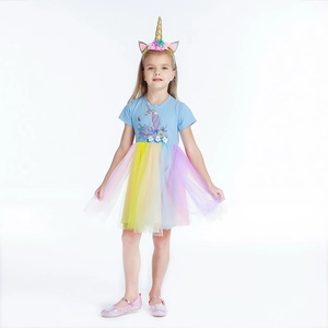 Close-up of unicorn embroidery and 3D floral waist detail on a girl's rainbow tulle dress