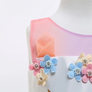 Dettaglio del vestito da unicorno con fiori 3D, paillettes e perle su tessuto a rete