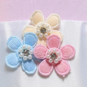 Dettaglio di fiori ricamati a mano con perle e strass su abiti da principessa per bambina