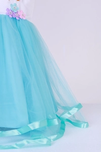 Détail de la jupe tutu en tulle bleu clair avec garniture satinée et fleurs 3D à la taille