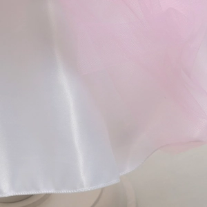 Dettaglio dell'orlo in tulle rosa multistrato e raso bianco su abito da principessa unicorno