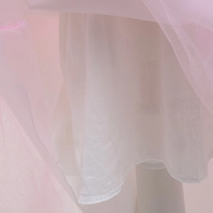 Dettaglio degli strati di tulle rosa e fodera bianca con bordi orlati sulla gonna da principessa