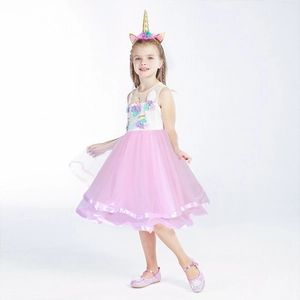 Détail de robe licorne rose avec broderies fleurs et bandeau corne dorée