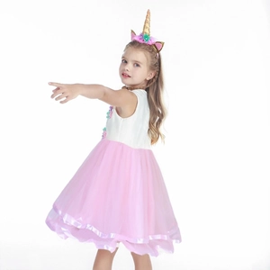 Détail d'une robe licorne pour fille avec fleurs 3D et serre-tête assorti à corne dorée