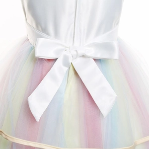Détail d'un grand nœud en satin blanc et des couches de tulle arc-en-ciel sur la robe