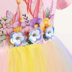 Detail von Einhorndruck mit 3D-Paillettenblumen und gelbem Netzrock auf dem Mädchenkleid