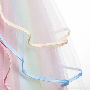 Détail des couches de tulle arc-en-ciel avec bordure en ruban sur une robe de fille