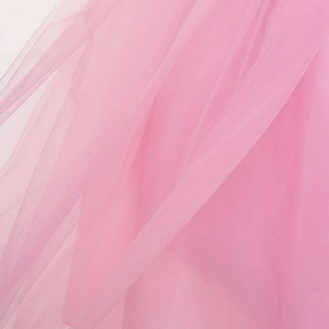 Gros plan sur le tissu en tulle rose clair de la robe de soirée licorne pour petites filles
