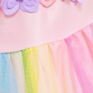 Dettaglio della gonna in tulle arcobaleno con fiori in vita per abito da principessa