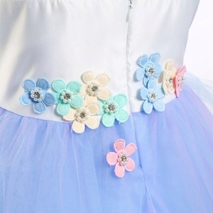 Détail de la taille fleurie en satin avec perles et strass sur robe de princesse