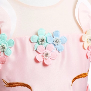 Détail de robe licorne avec appliques florales 3D et broderies dorées fines