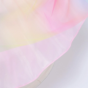 Dettaglio del tessuto a rete in tulle sfumato arcobaleno con cuciture per abito da bambina