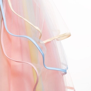 Détail de la jupe en tulle multicolore à couches avec volants pastel et bordure ondulée fine