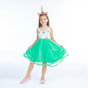 Détail d'une robe licorne pour fille avec jupe en tulle vert et bandeau floral assorti