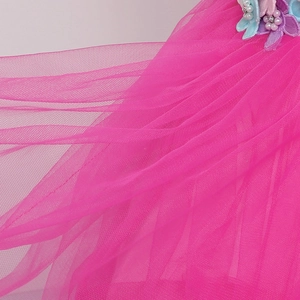 Dettaglio di maglia fucsia con applicazioni floreali 3D colorate e perle fini