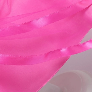 Dettaglio ravvicinato del tessuto in tulle rosa acceso con bordo in nastro di raso lucido