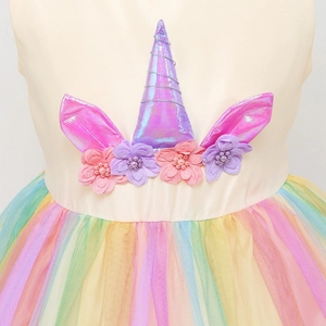 Dettaglio dell'abito da unicorno con fiori 3D e gonna in tulle arcobaleno