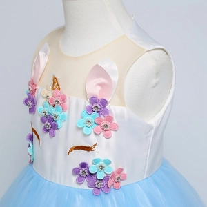 Dettaglio dell'abito unicorno con fiori 3D, perle e gonna in tulle blu a più strati