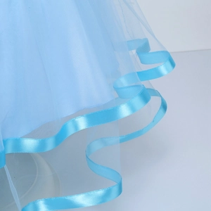 Dettaglio degli strati di tulle blu brillante e bordi in raso di un abito da bimba