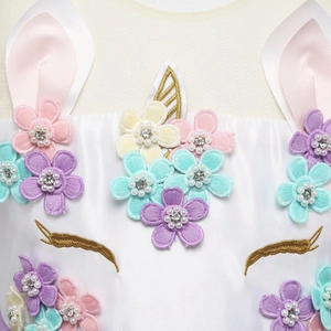 Dettaglio dell'abito da unicorno con fiori 3D, ricami dorati e strass di perle