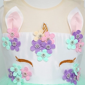 Dettaglio del vestito da unicorno con fiori 3D pastello, perle e ricamo di ciglia