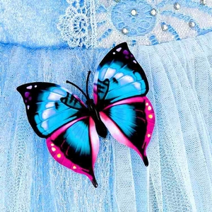 Detail of a 3D butterfly applique with rhinestones on light blue tulle and lace dress