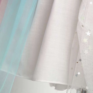 Vue détaillée du tulle bleu et du tissu blanc avec des étoiles argentées brillantes