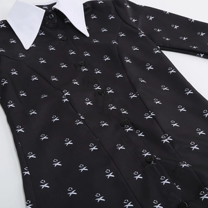 Close-up of Adams family style black dress featuring white Peter Pan collar and icon prints