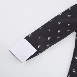 Detail of black sleeve with white XO pattern and contrasting white cuff stitching