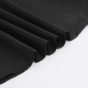 Close-up of Adams family Wednesday black dress hemline with high-quality fabric folds