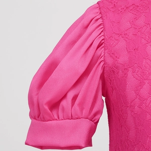 Detail of pink girls' dress showing lace bodice and satin puff sleeves textures