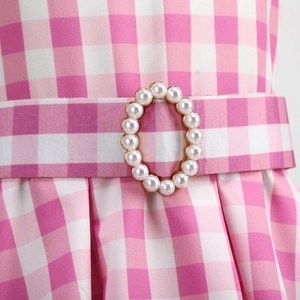 Macro detail of pink plaid dress with a vintage pearl-encrusted buckle on waist belt