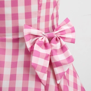 Detailed view of pink and white gingham fabric with a large bow on a girl's princess dress
