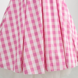 Detail of pink gingham dress fabric showing layered white mesh tulle lining and full hem