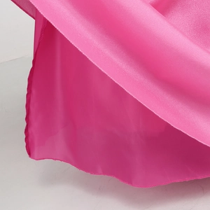 Detailed close-up of glossy pink satin dress hem featuring precise overlock stitching edge