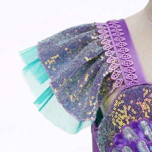 Détail de robe sirène avec volants à paillettes, broderie de coquillages et perles