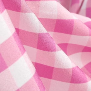 Macro detail of the pink gingham dress fabric with smooth silk-like texture and weave